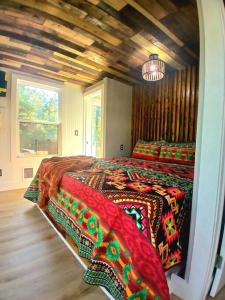 a bedroom with a large bed with colorful blankets at Waterfront Container House In A Magical Forest! in Waller