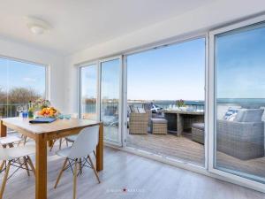 una sala da pranzo con tavolo e vista sull'oceano di An-der-Ostsee-17 Comfortable holiday residence a Kappeln