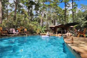 a pool with two people sitting in the water at Waterfront Container House In A Magical Forest! in Waller