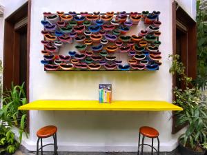 a wall with a bunch of colorful bowls on a wall at Snooze Malang in Malang