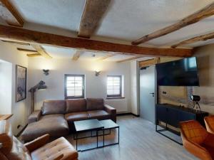 a living room with a couch and a flat screen tv at holiday apartment Vollmer´s Hof in Bad Berleburg