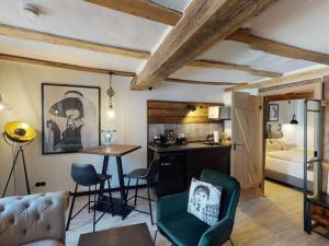 a living room with a table and chairs and a bed at holiday apartment Vollmer´s Hof in Bad Berleburg