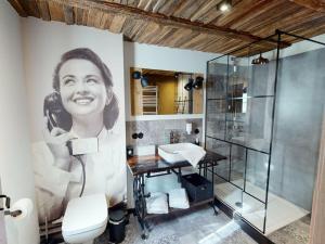 a bathroom with a painting of a woman talking on the phone at holiday apartment Vollmer´s Hof in Bad Berleburg
