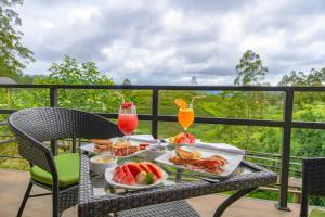 a table with food and drinks on a balcony at La Casa Lindula Villa Eliya in Nuwara Eliya