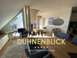 Una sala de estar con un sofá y un comedor. en luxury holiday apartment Duhnenblick, en Duhnen