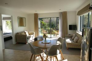a living room with a table and chairs at Patons Rock Beach Villas in Takaka