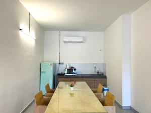 a kitchen with a long wooden table and chairs at Garden Home Ipoh in Ipoh