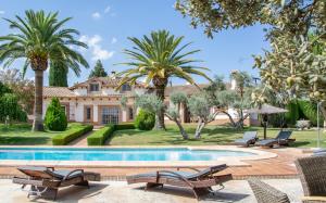 アリアテにあるAndalusische Luxus-Finca Villa La Almunia Garden Rondaのヤシの木とスイミングプールのある家