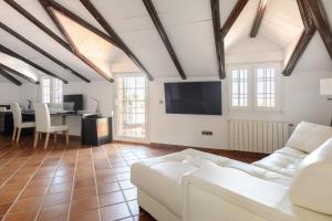 アリアテにあるAndalusische Luxus-Finca Villa La Almunia Garden Rondaの白いソファとテレビのあるリビングルーム