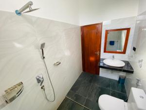 a bathroom with a toilet and a sink at Aqua Hotel in Aluthgama +11 photos