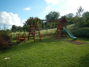 a playground with a slide and a swing set at Berki Porta Vendégház in Dinnyeberki
