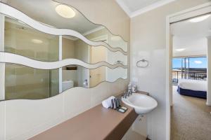 un bagno con lavandino e specchio di Oceanfront 3-Bed Retreat with Pool-Steps to Beach a Caloundra