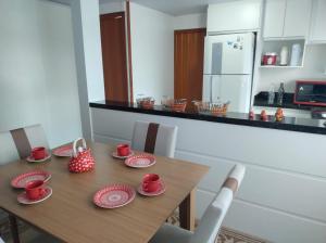 弗洛里亚诺波利斯Brisa da Ilha - Estúdios ao lado do aeroporto的餐桌上放着红杯和盘子