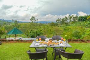 a table with food and drinks on top of a yard at La Casa Lindula Villa Ceylon in Lindula