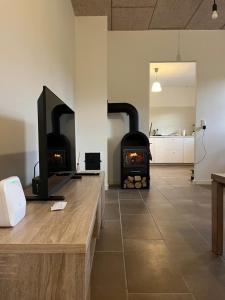 a living room with a stove in a room at Countryside home 300m to the Fishing river Lille Ø in Langå