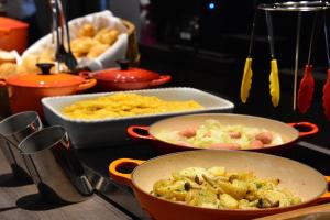a counter with three pans of food on a counter at RIHGA PLACE HIGOBASHI in Osaka