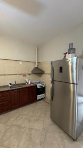 a kitchen with a stainless steel refrigerator and a stove at La casa de los abuelos in Santiago del Estero