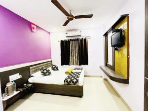 a small room with a bed and a tv at Sai Balaji Residency shirdi near sai temple in Shirdi