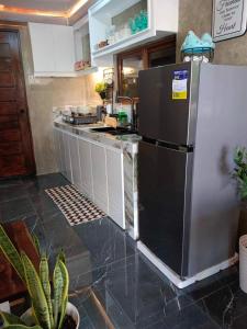 une cuisine avec un réfrigérateur en acier inoxydable et un comptoir dans l'établissement Edimir Cabin House, à Tagaytay