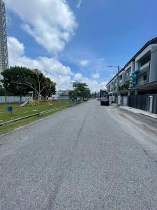 una strada vuota con un'auto parcheggiata sulla strada di Brand new house with Karaoke room near to jonker Netflix 18 pax by Doraee Home a Malacca
