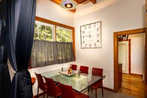 a dining room with a glass table and red chairs at Cozy Cedar Cabin Near Silverwood Theme Park - Sleeps 5 - Quiet & Private in Spirit Lake