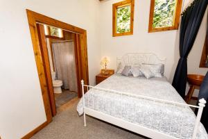 a bedroom with a white bed and a toilet at Cozy Cedar Cabin Near Silverwood Theme Park - Sleeps 5 - Quiet & Private in Spirit Lake
