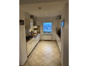 a kitchen with white cabinets and a window at Studio 2 with sea view in Lohme