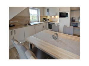 ノルトダイヒにあるHoliday apartment Stopperstekのキッチン(木製テーブル、椅子、カウンター付)