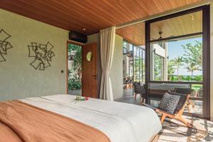 a bedroom with a large bed and a balcony at Sea View Pool Villa - Exclusive Beachfront Property in Buleleng