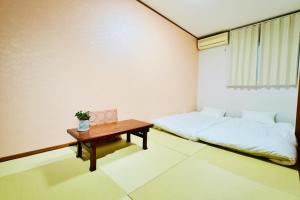 una pequeña habitación con una cama y una mesa en 京都佳月民宿, en Kioto