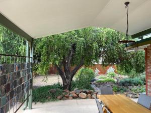 a patio with a table and a tree at The Eagle's Nest in Manilla