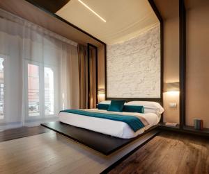 a bedroom with a large bed with blue pillows at Dharma Luxury Hotel in Rome