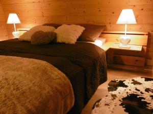 Un dormitorio con una cama con dos lámparas y un perro. en Gite Au Coeur Du Chalet en Belledonne vers Prapoutel Les 7 Laux en Sainte-Agnès