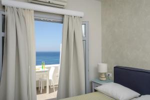 Schlafzimmer mit einem Fenster mit Meerblick in der Unterkunft Hotel Grotta in Naxos Chora