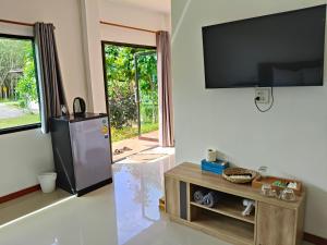 a living room with a flat screen tv on the wall at The Lodge at Koh Kood in Ko Kood