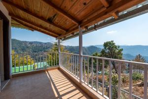 un balcon avec vue sur les montagnes dans l'établissement Pet-Friendly mountain view 2 bedroom cottage C1, à Mukteswar