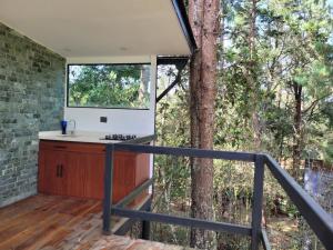 una cocina en la terraza de una casa en un árbol en Cabaña Aventurina- La pascana Ecolodge Entorno natural excepcional, conexión con la naturaleza y avistamiento de aves, Ubicado a 3km del metrocable y Parque Arvi, Guarne, en Mazo