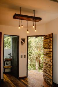 una puerta abierta a una habitación con una pared de piedra en Cabaña Aventurina- La pascana Ecolodge Entorno natural excepcional, conexión con la naturaleza y avistamiento de aves, Ubicado a 3km del metrocable y Parque Arvi, Guarne, en Mazo