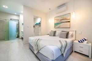 a bedroom with a large bed and a bathroom at Belle Escapes Luxury Beach Edge in Palm Cove +25 photos