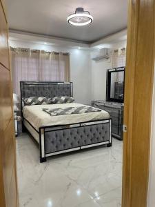 Un dormitorio con una cama grande y un espejo. en Modern House in Santo Domingo Este, en Juan López