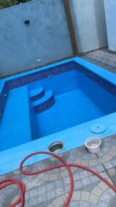 Una piscina con una manguera roja al lado. en Modern House in Santo Domingo Este, en Juan López