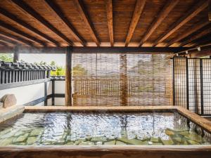 a pool of water in a house with a wooden ceiling at 伊豆Cocoグランピングリゾート in Ito