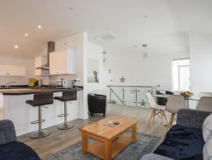 a kitchen and a living room with a table and a couch at 3 Marina View in Pwllheli