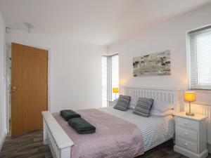 a bedroom with a bed with two pillows on it at 3 Marina View in Pwllheli