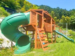 a playground with a slide in the grass at 伊豆Cocoグランピングリゾート in Ito
