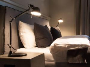 a bedroom with a bed with pillows and a lamp at Oceans 18 Comfortable holiday residence in Wenningstedt