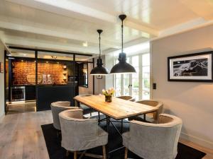 a dining room with a wooden table and chairs at Oceans 18 Comfortable holiday residence in Wenningstedt