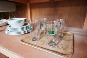 four empty glasses sitting on a tray on a table at Yellow House Kuruwa in Hayama