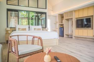 ペッチャブリーにあるVilla De Leaf River Kaeng Krachanのベッドルーム(ベッド1台、椅子、テレビ付)
