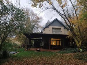een huis in het midden van een tuin met bomen bij Little Fields Country House and Cottages in Howick